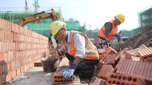 10月1日，建筑工人在龍興智能制造基地二期項(xiàng)目工地堅(jiān)守施工。中建六局供圖