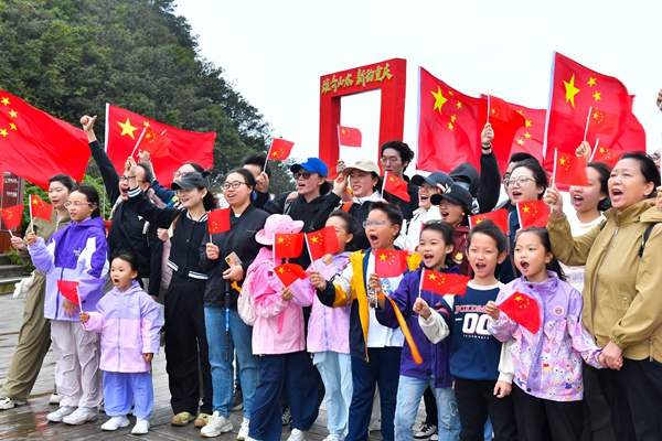 游客們揮舞國旗表達對祖國的美好祝愿。景區(qū)供圖