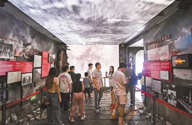 10月1日，渝中區(qū)重慶大轟炸“六五”隧道慘案史實(shí)展館，游客們帶著孩子正在了解抗戰(zhàn)歷史。記者 鄭宇 攝/視覺重慶