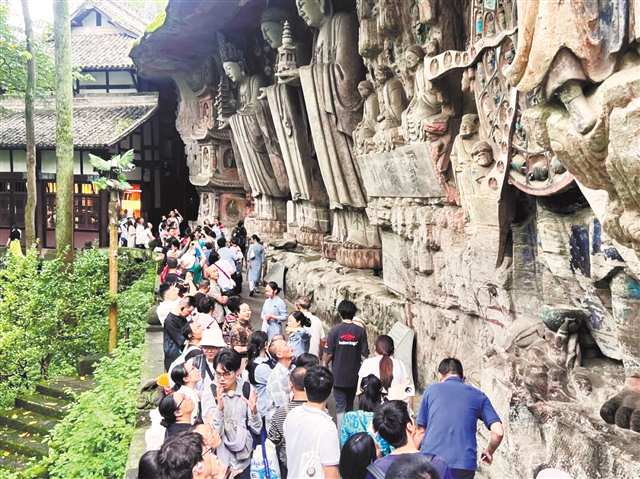 國(guó)慶期間，游客參觀大足石刻寶頂山景區(qū)的華嚴(yán)三圣。（受訪單位供圖）