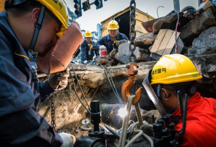 近日，大渡口區(qū)鋼花路，搶險(xiǎn)班班長(zhǎng)劉瀚林和同事李學(xué)武在閥井作業(yè)坑里焊接燃?xì)庵鞴荛y門(mén)。記者 張錦輝 攝/視覺(jué)重慶