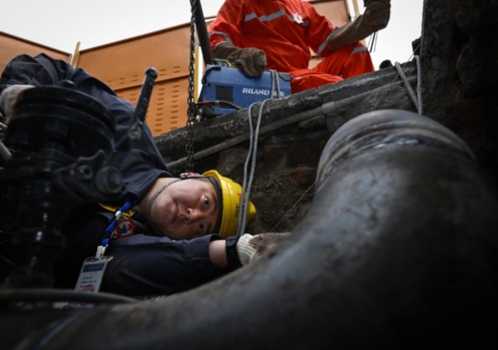 近日，大渡口區(qū)鋼花路，搶險(xiǎn)班班長(zhǎng)劉瀚林在閥井作業(yè)坑里檢查焊口焊接質(zhì)量。記者 張錦輝 攝/視覺(jué)重慶