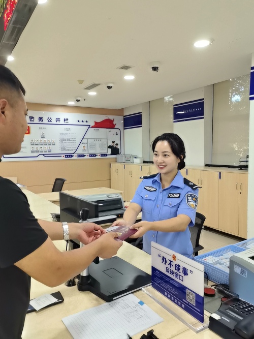 王先生從輔警手中接過身份證和港澳通行證。南岸區(qū)公安分局供圖