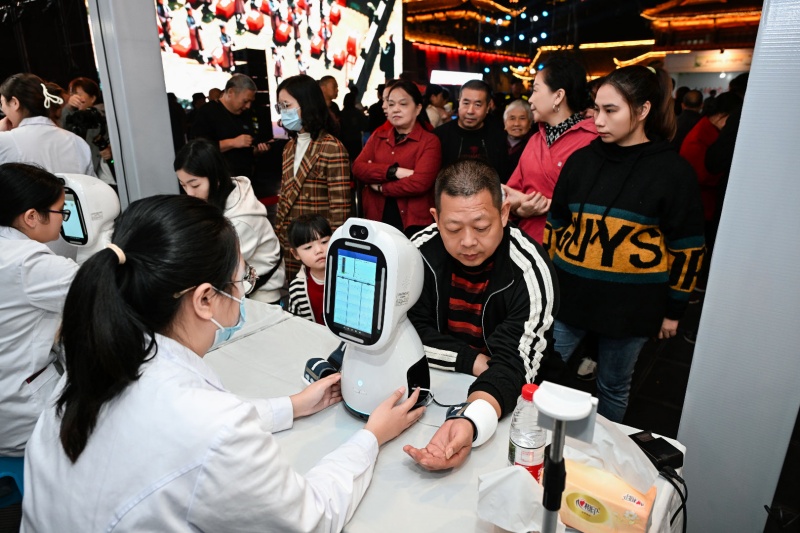 市民現(xiàn)場(chǎng)體驗(yàn)中醫(yī)智能機(jī)器人脈診。主辦方供圖