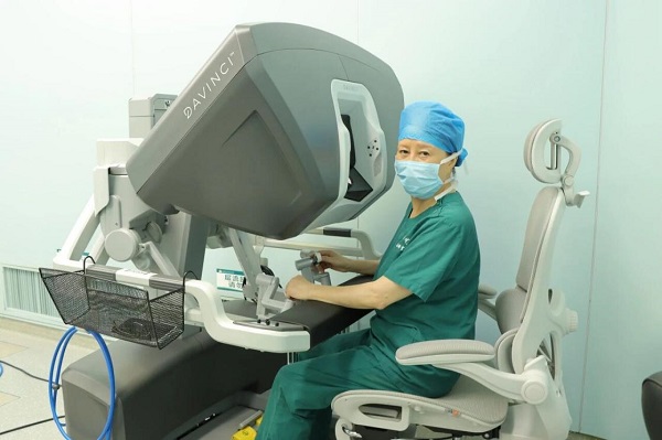 唐均英在手術(shù)機(jī)器人系統(tǒng)前準(zhǔn)備進(jìn)行操作。重醫(yī)附屬大學(xué)城醫(yī)院供圖