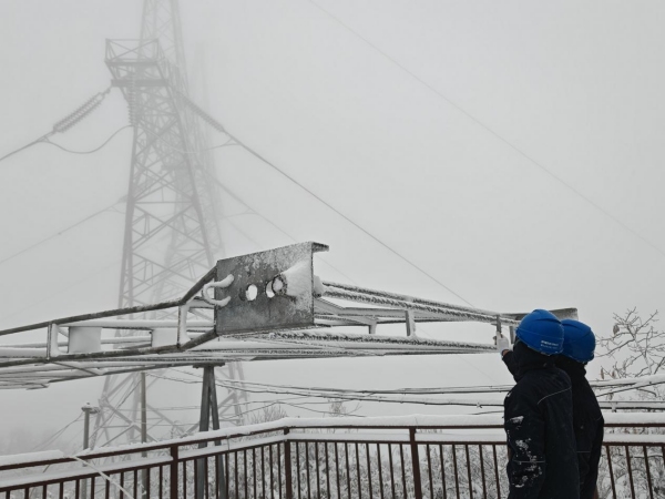 11月17日，國(guó)網(wǎng)重慶城口供電公司員工陳倫武、張磊在220千伏華城線237號(hào)塔利用游標(biāo)卡尺測(cè)量模擬導(dǎo)線覆冰厚度。黃都攝