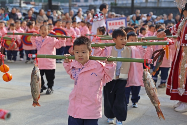 孩子們用扁擔擔著農產品，喜慶豐收。趙勇攝