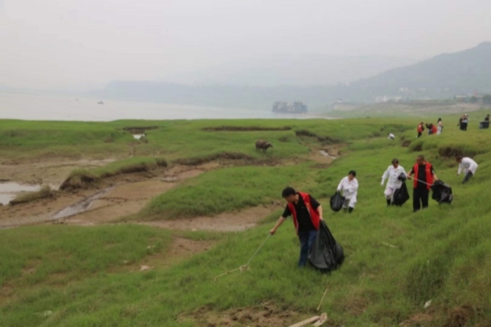 志愿者在長(zhǎng)江岸邊清理垃圾。景區(qū)供圖