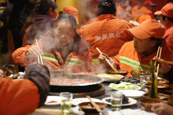 環(huán)衛(wèi)工人與保潔人員一起免費(fèi)享用火鍋大餐。楊孝永攝